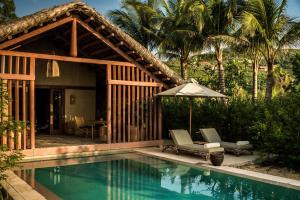 a villa with a swimming pool and a house at Zannier Bai San Hô in Song Cau