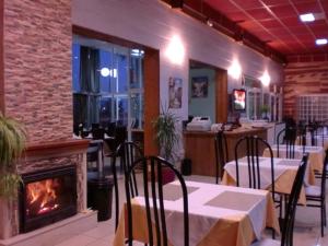 a restaurant with tables and chairs and a fireplace at Hotel Lo Monte in Pilar de la Horadada
