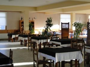 a dining room with tables and chairs with plants at Hotel Costa Verde in Villadesuso +18 photos