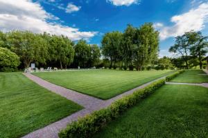 a grassy field with a pathway in a park at Moscatello & Mulinër Design Agri Relais in Pozzolengo +84 photos