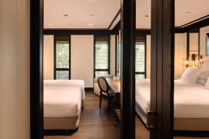 a bedroom with two beds and a desk with a chair at Seventy Barcelona in Barcelona