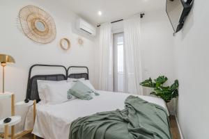 Habitación blanca con cama y ventana en Casa Boma Lisboa - Design and Sunny Apartment - Lapa I, en Lisboa