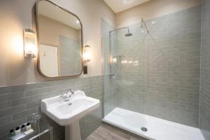 a bathroom with a sink and a shower with a mirror at Cottage In The Wood in Great Malvern +132 photos