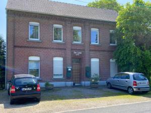 two cars parked in front of a brick building at Work & Stay in Bedburg-Hau II in Louisendorf