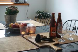 a table with two bottles of wine and a bowl of fruit at Apartament Pod Tężnią in Głuchołazy