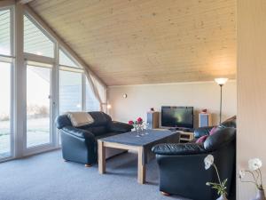 a living room with two couches and a table at Tranquil Cottage with Spa and Sauna-By Traum in Hemmet