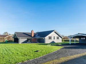 a house with a grass yard in front of it at Tranquil Cottage with Spa and Sauna-By Traum in Hemmet