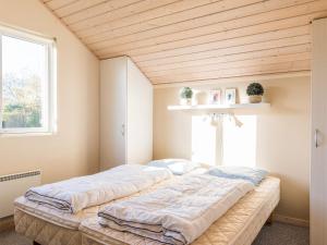 a large bed in a room with a window at Tranquil Cottage with Spa and Sauna-By Traum in Hemmet