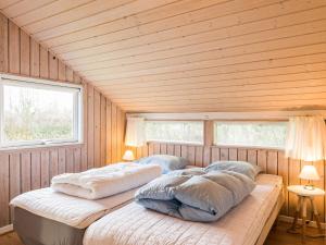2 camas num quarto de madeira com 2 janelas em Holiday home Hemmet CXCIII em Hemmet