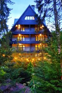 una gran casa de madera con luces en los árboles en Hotel Smart, en Sinaia