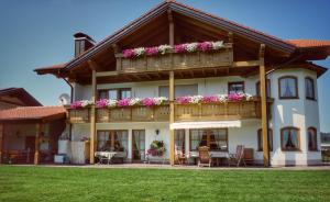 una casa con un balcón con flores. en Gästehaus "Zur Schmiede" en Wertach