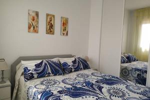 1 dormitorio con 1 cama con sábanas azules y blancas en Apartamento en Arcos de Font Nova (4-6), en Peñíscola