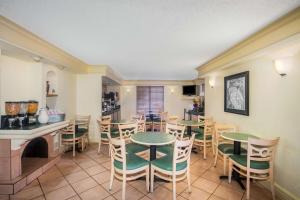 a dining room with tables and chairs and a kitchen at La Quinta Inn by Wyndham Eagle Pass in Eagle Pass