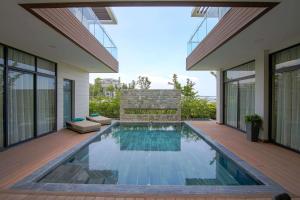 - une piscine dans l'arrière-cour d'une maison dans l'établissement Wyndham Grand KN Paradise Cam Ranh, à Cam Ranh