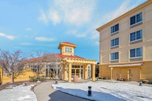 a large yellow building with a red roof in the snow at La Quinta by Wyndham Salt Lake City Airport in Salt Lake City