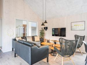 Una sala de estar con un sofá y sillas y una mesa. en 26 person holiday home in Nørre Nebel, en Nørre Nebel