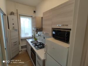 a small kitchen with a stove and a microwave at Casa di Teo in Rapallo