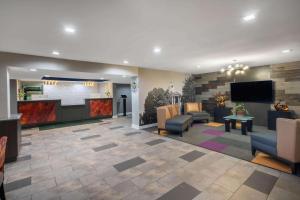 een lobby met stoelen en een flatscreen-tv bij Baymont by Wyndham Murfreesboro in Murfreesboro