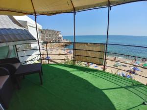 a balcony with a view of a beach and the ocean at Котеджі на приватному пляжу - Совіньон 2024 in Odesa