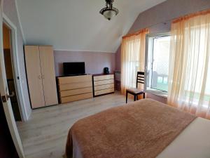 1 dormitorio con 1 cama, TV y ventana en Котеджі на приватному пляжу - Совіньон 2024 en Odesa
