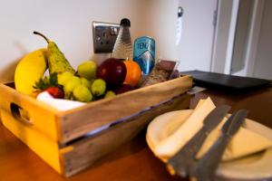 een houten doos fruit op een tafel met een bord bij Mitchell Hall in Cranfield