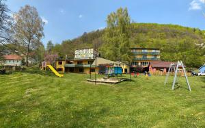 une maison avec une aire de jeux en face d'un bâtiment dans l'établissement Die Hardtmühle, à Bergfreiheit