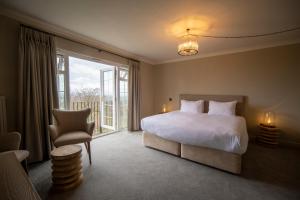 a bedroom with a bed and a large window at Cottage In The Wood in Great Malvern
