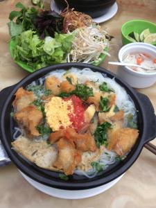 a bowl of food on a table with noodles at Duc Thang Guest House (Nhà Nghỉ Đức Thắng) in Diện Biên Phủ