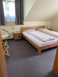 una camera da letto con due letti, una sedia e una finestra di Hotel Tannenhof a Steinen