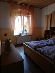 1 dormitorio con 1 cama y una ventana con flores en Ferienwohnung Gladbeck-Rohde en Gladbeck