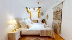 a bedroom with a white bed and a window at Duplex des Dominicains - 1 Parking GRATUIT - Hypercentre 6 personnes in Colmar