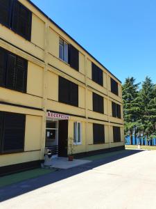 een geel gebouw met een ziekenhuisbord erop bij Youth Hostel Pinesta in Novigrad Istria
