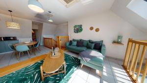 ein Wohnzimmer mit einem Sofa und einem Tisch in der Unterkunft Duplex des Dominicains - 1 Parking GRATUIT - Hypercentre 6 personnes in Colmar