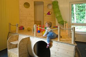 un jeune enfant jouant dans une salle de jeux dans l'établissement Ferienstätte und Seminarhaus Theodor-Schwartz Travemünde, à Lübeck