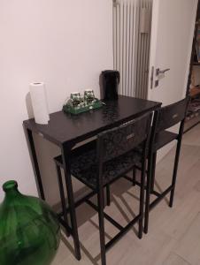 a black table with two chairs and acomputer on it at Francesca house in Erba