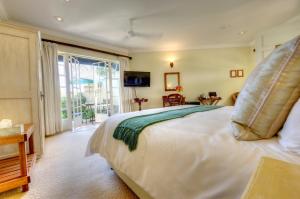 a bedroom with a large white bed and a window at Moorcroft Manor Boutique Country Hotel in Himeville