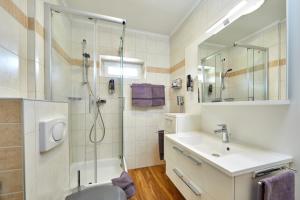 a bathroom with a shower and a sink and a toilet at Gästehaus Buchenhof in Grainau