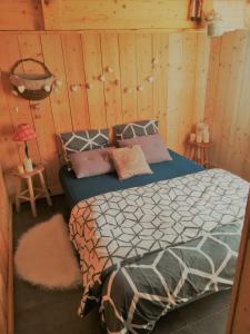 sypialnia z łóżkiem w drewnianej ścianie w obiekcie Logicoeur w mieście Gérardmer
