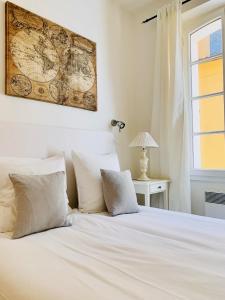 サントロペにあるMaison Saint-Tropezのベッドルーム1室(壁に地図が貼られた白いベッド1台付)