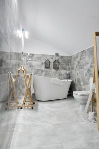 a bathroom with a white tub and a toilet at Armada Apart Ustka in Ustka