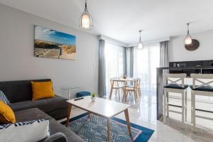 een woonkamer met een bank en een tafel bij Resort Apartamenty Klifowa Rewal 31 in Rewal