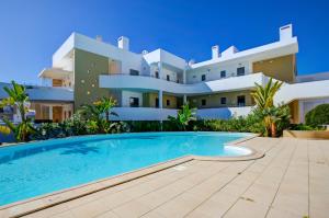 a villa with a swimming pool in front of a building at One Bedroom Apartment in Albur Village 2J in Alvor