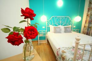 ティミショアラにあるStudio Cozy 24のベッドルームのテーブルに赤いバラが飾られた花瓶