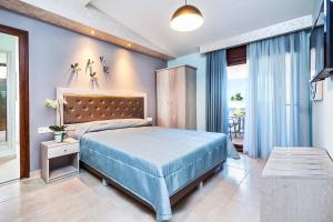 a blue bedroom with a bed and a balcony at Anna Maria Paradise in Pefkochori +167 photos
