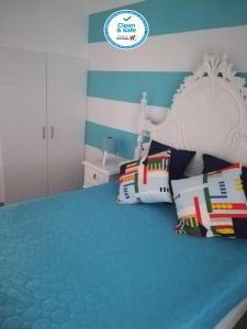 um quarto com uma cama com uma cabeceira branca e almofadas em Casa da Avó Lucinda na Nazaré