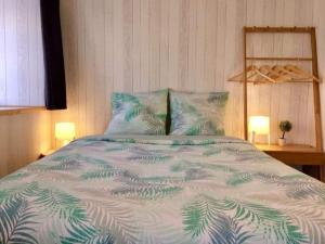 um quarto com uma cama com um edredão verde e branco em grasset rittiron em Ouides