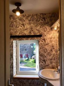 a bathroom with a window next to a sink at grasset rittiron in Ouides