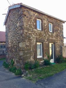 ein altes Steinhaus mit zwei Fenstern auf einer Straße in der Unterkunft grasset rittiron in Ouides