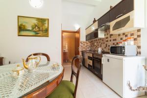 cocina con mesa, sillas y microondas en Apartments villa Mira, en Kaštela