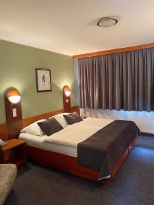 a bedroom with a large bed and a window at Hotel Tripič, restaurant and pizzeria in Bohinj